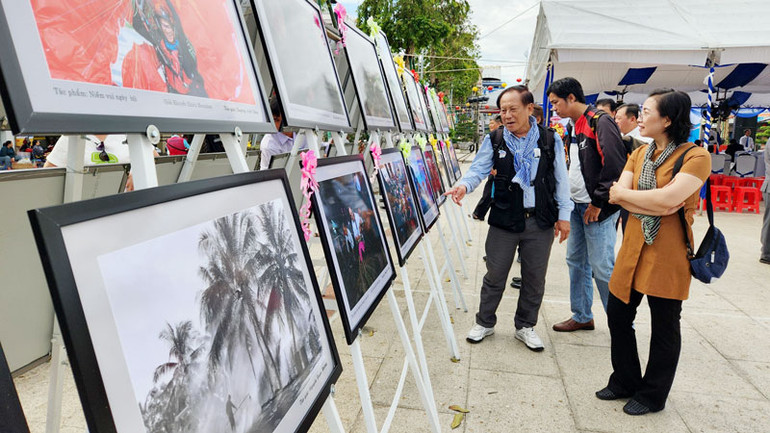 Đại biểu tham quan trưng bày triển lãm ảnh.