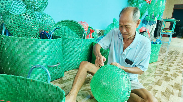 Ông Nguyễn Văn Lẹ đan rổ dùng để rửa cá, thịt.