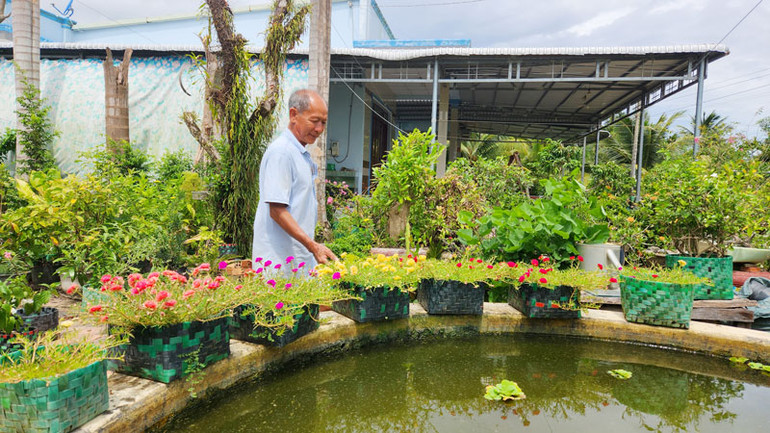 Những sợi dây nhựa buộc gạch tưởng chừng bỏ đi, được ông Nguyễn Văn Lẹ đan thành chậu trồng hoa kiểng.