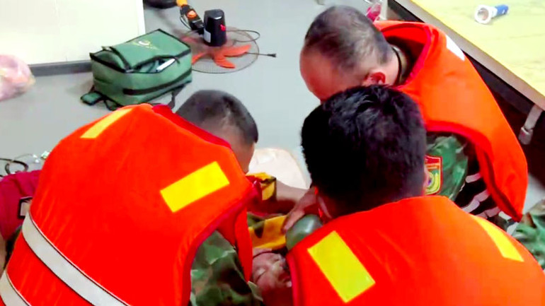 Lực lượng chức năng sơ cứu ban đầu cho ngư dân gặp nạn. (Ảnh: Biên phòng Kiên Giang cung cấp).