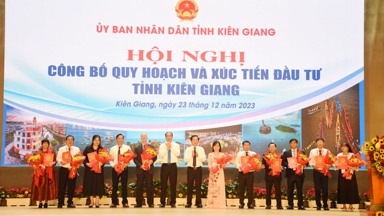 Lãnh đạo tỉnh Kiên Giang trao quyết định chủ trương đầu tư và tặng hoa cho các nhà đầu tư tại hội nghị.