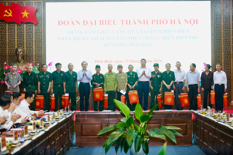 Đồng chí Nguyễn Ngọc Tuấn, Phó Bí thư Thành ủy, Chủ tịch Hội đồng nhân dân thành phố Hà Nội cùng các đồng chí trong đoàn công tác Thành ủy Hà Nội trao quà tặng các gia đình chính sách tỉnh Điện Biên.