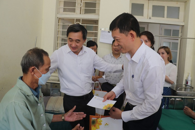 Thứ trưởng Y tế Trần Văn Thuấn cùng bác sĩ trong đoàn công tác trao quà hỗ trợ bệnh nhân đang được chăm sóc, điều trị tại Bệnh viện đa khoa tỉnh Điện Biên.