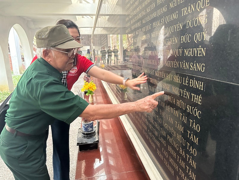 Ông Trương Sỹ Trì tìm tên đồng đội trên bảng vàng trong Nghĩa trang liệt sĩ A1.