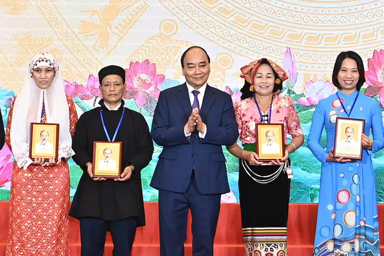 Chủ tịch nước Nguyễn Xuân Phúc trao quà tặng các cán bộ Mặt trận Tổ quốc tiêu biểu toàn quốc. (Ảnh: ĐĂNG KHOA)