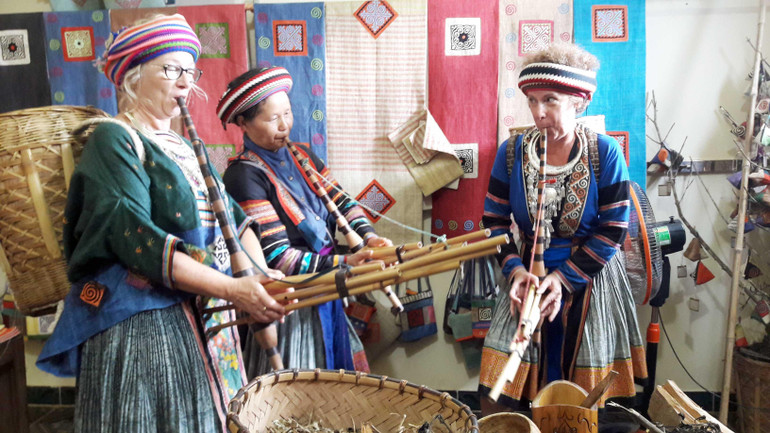 Đồng bào H’Mông hướng dẫn du khách nước ngoài trải nghiệm cây khèn truyền thống tại xã văn hóa Lùng Tám, huyện Quản Bạ. (Ảnh PHẠM PHƯỜNG)