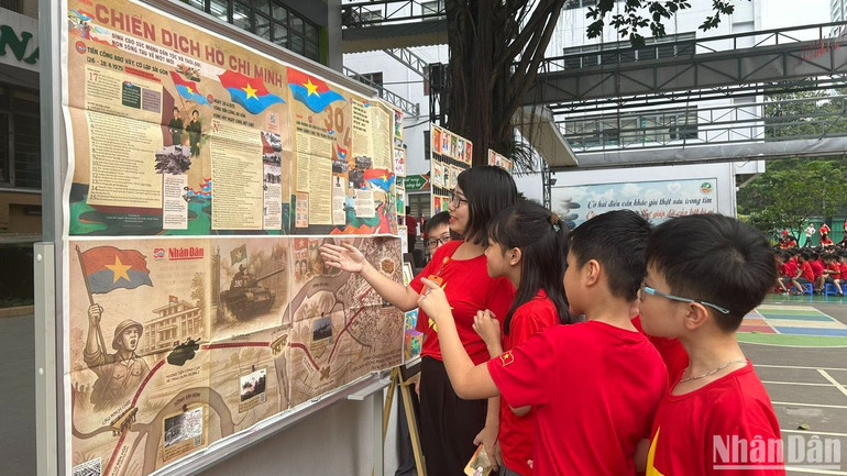 Các em học sinh hứng thú tìm hiểu phụ san đặc biệt của Báo Nhân Dân.