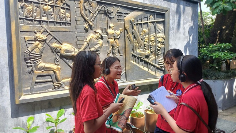 Học sinh vừa đọc báo, vừa trao đổi về những câu chuyện lịch sử.