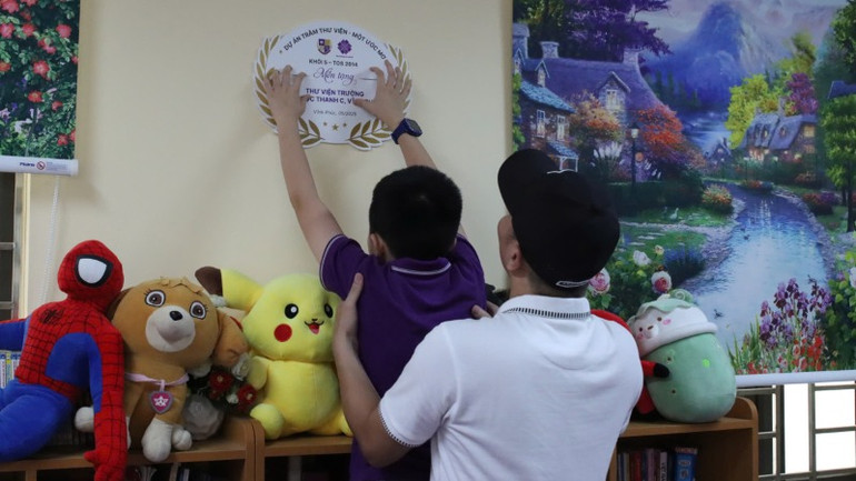 Người lớn và trẻ thơ chung tay xây dựng thư viện cho trường bạn.