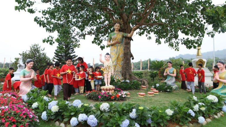 Thiếu nhi dâng hoa tại vườn Phật đản sinh.
