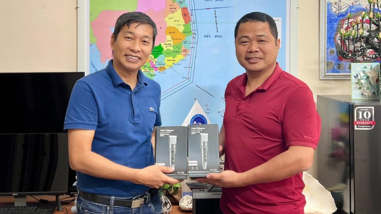 Anh Trần Xuân Sơn (bên phải) đi từ Lào Cai xuống Hà Nội để tặng tông đơ cắt tóc cho bộ đội.