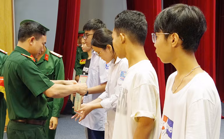 Đại tá Nguyễn Tiến Quang, Chính ủy Bộ Chỉ huy quân sự tỉnh Thái Bình trao quà cho các cháu học sinh có hoàn cảnh khó khăn đạt thành tích cao trong học tập.