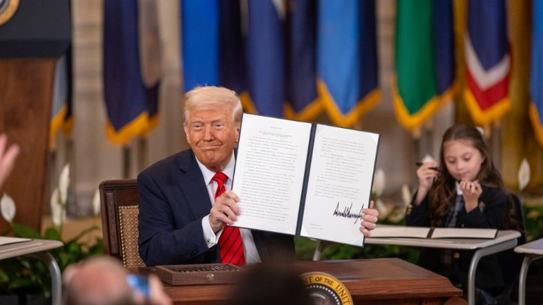 Tổng thống Mỹ D.Trump giơ cao sắc lệnh hành pháp đã ký tại Nhà Trắng ở Washington, D.C., Hoa Kỳ, vào ngày 20/3/2025. (Ảnh: Tân Hoa xã)