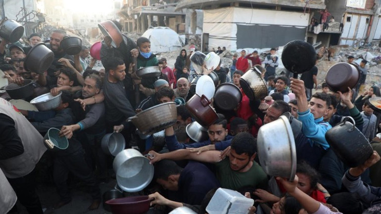 Người dân xếp hàng trước một bếp ăn từ thiện để nhận đồ ăn tại trại tị nạn Jabalia, phía bắc Dải Gaza. (Ảnh: Tân Hoa xã) Người dân xếp hàng trước một bếp ăn từ thiện để nhận đồ ăn tại trại tị nạn Jabalia, phía bắc Dải Gaza. (Ảnh: Tân Hoa xã)