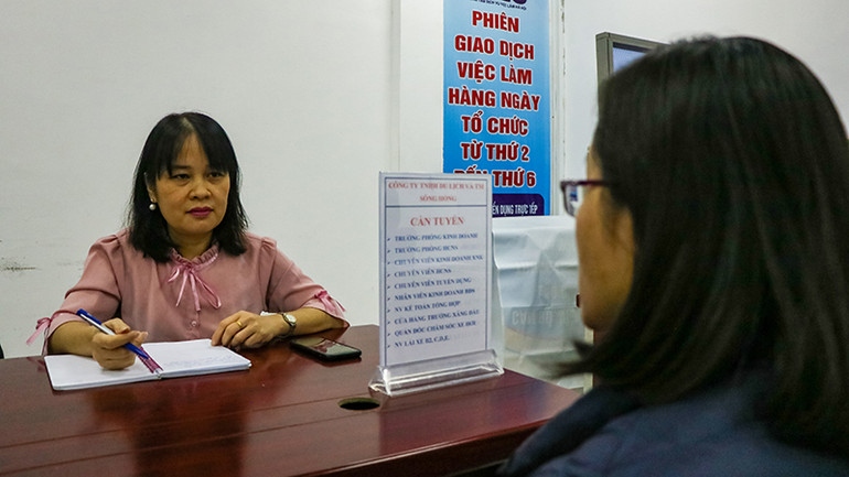 Người lao động tìm hiểu thông tin tại doanh nghiệp trong phiên giao dịch việc làm ngày 9/3. (Ảnh: Nhật Quang)