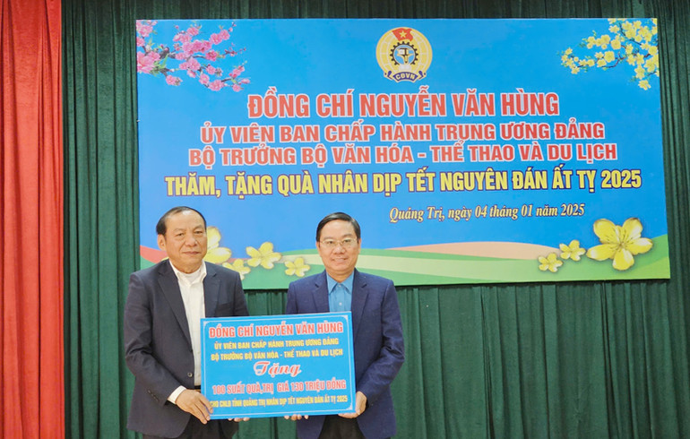 Chủ tịch Liên đoàn Lao động tỉnh Quảng Trị Nguyễn Thế Lập (phải) thay mặt công đoàn nhận quà từ Bộ trưởng Văn hóa, Thể thao và Du lịch Nguyễn Văn Hùng.