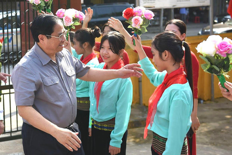 Các em học sinh đón chào Thủ tướng đến thăm trường.