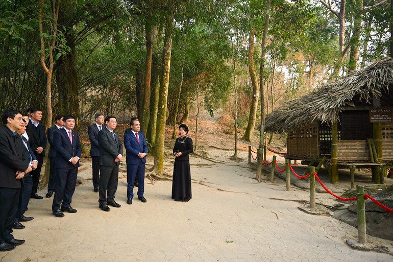 Nhân viên Khu di tích quốc gia đặc biệt Tân Trào giới thiệu về Lán Nà Nưa cho Chủ tịch Quốc hội và các đại biểu.