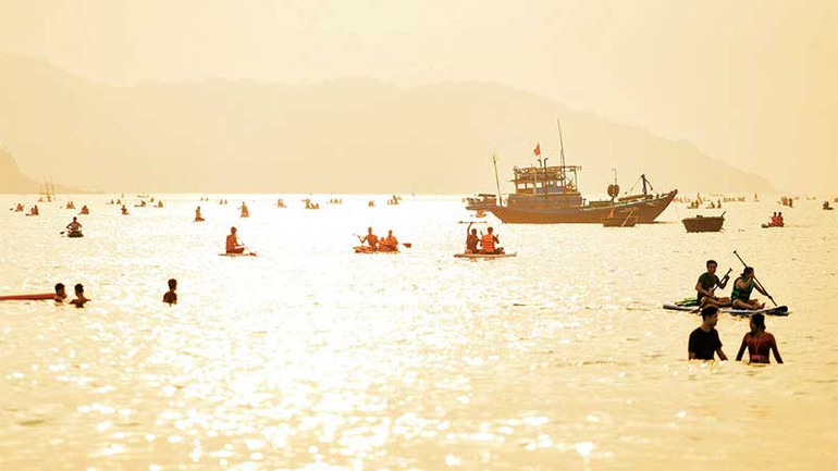 Du khách đón bình minh trên biển.