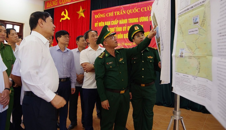 Đồng chí Trần Quốc Cường, Ủy viên Trung ương Đảng, Bí thư Tỉnh ủy Điện Biên nghe Đại tá Phan Văn Hóa, Chỉ huy trưởng Bộ Chỉ huy Bộ đội Biên phòng tỉnh Điện Biên báo cáo tiến độ triển khai xây dựng cột cờ tại xã Sín Thầu, huyện Mường Nhé.