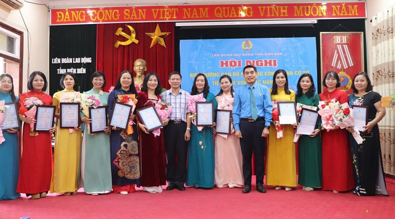 Chủ tịch Liên đoàn Lao động tỉnh Điện Biên Tẩn Minh Long và lãnh đạo Ban Dân vận Tỉnh ủy Điện Biên tặng hoa chúc mừng các cán bộ nữ công Công đoàn được vinh danh.