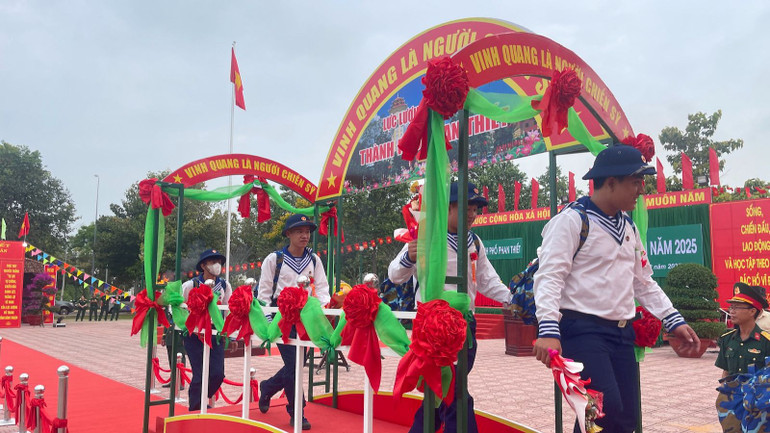 Các tân binh cầm những bông hoa tươi thắm lên đường nhập ngũ.