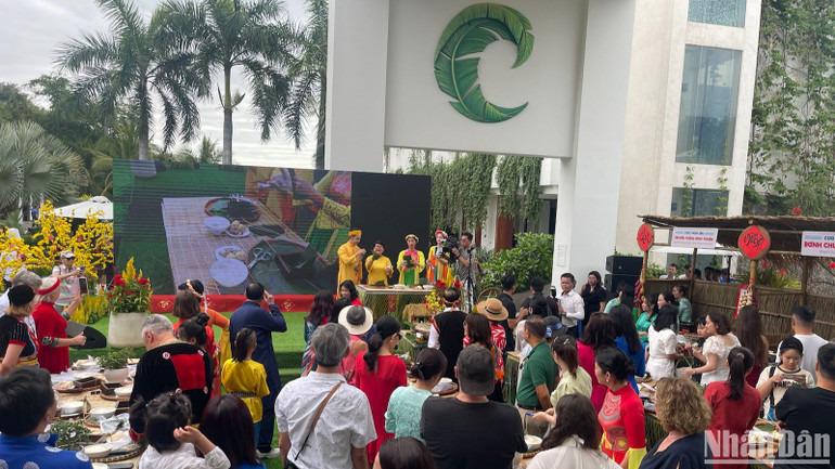 Các du khách lắng nghe đầu bếp hướng dẫn cách gói bánh chưng.