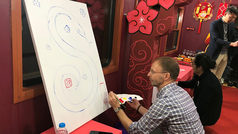 Họa sĩ người Anh John Lester sáng tác trên Chuyến tàu xuân.