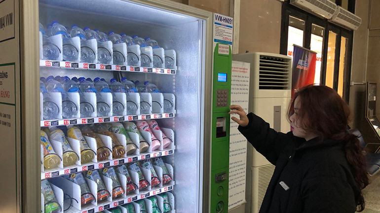 Hành khách mua hàng tự động tại phòng đợi nhà ga.