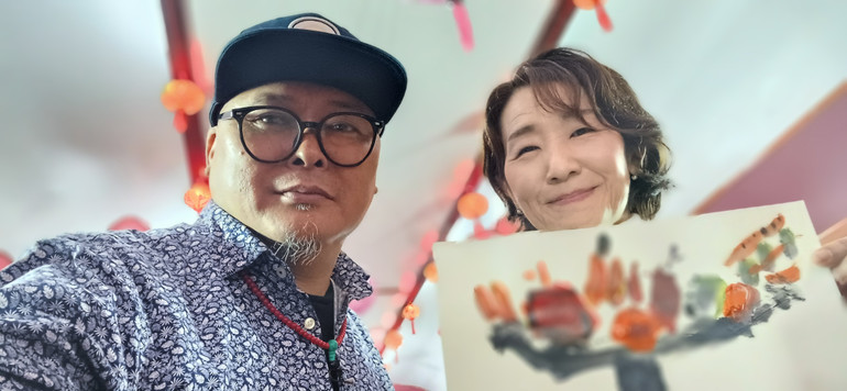 Họa sĩ Nguyễn Nam Đồng vẽ tranh tặng hành khách Aikiko người Nhật.