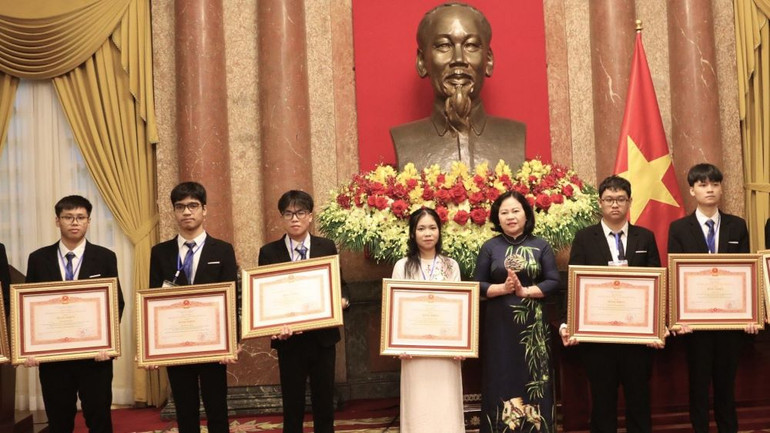 Thứ trưởng Bộ Giáo dục và Đào tạo Ngô Thị Minh trao Bằng khen của Thủ tướng Chính phủ tặng các học sinh, vì đã có thành tích xuất sắc.