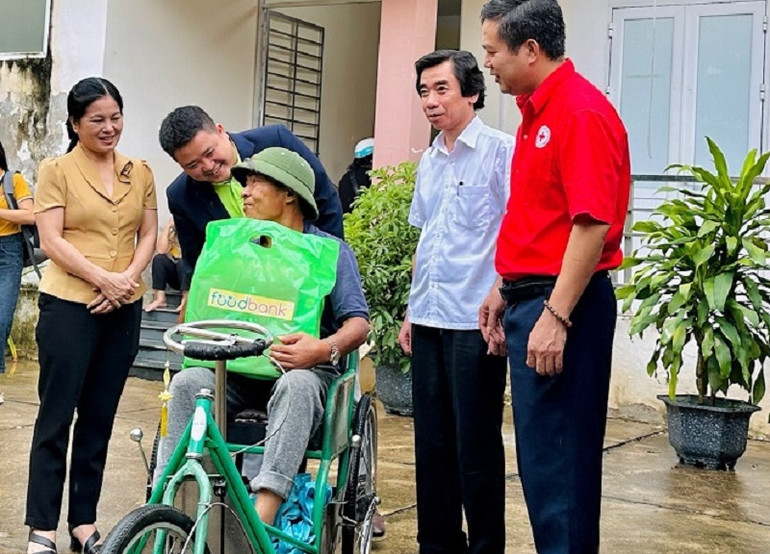 Đại diện các đơn vị tặng quà, thăm hỏi một hộ dân nhận quà tại chương trình.