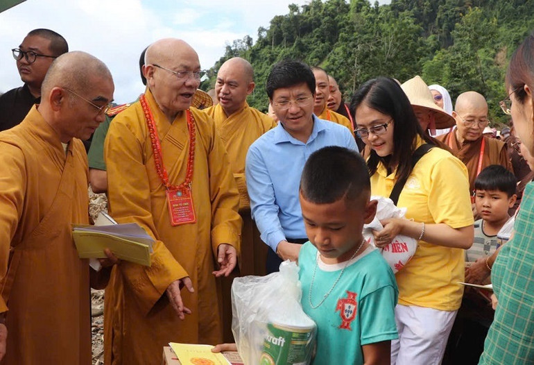 Hòa thượng Thích Quảng Tùng cùng đồng chí Mùa A Vảng, trao quà tặng người dân vùng lũ.