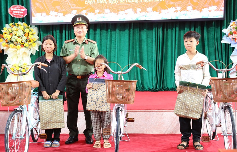 Đại tá Nguyễn Thanh Bình, Phó Cục trưởng Cục Xây dựng phong trào "Toàn dân bảo vệ an ninh Tổ quốc" Bộ Công an tặng quà các cháu học sinh là con em công nhân Công ty cổ phần cao-su Điện Biên.