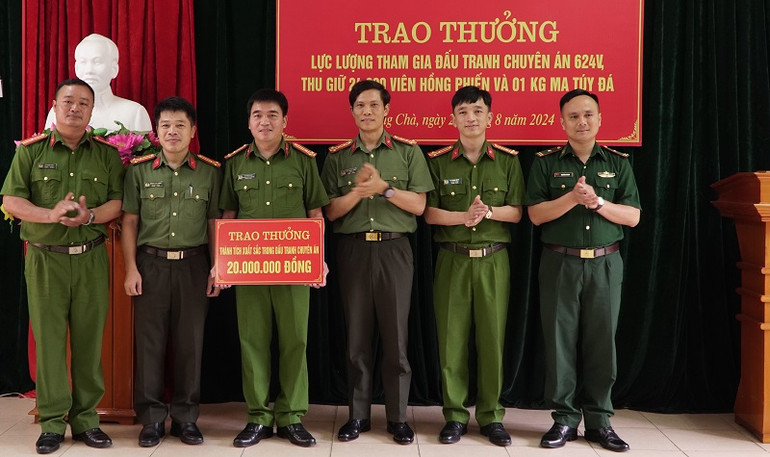 Đại tá Ngô Thanh Bình (thứ ba từ phải sang), Giám đốc Công an tỉnh Điện Biên trao thưởng các tập thể, cá nhân thuộc Công an huyện Mường Chà có thành tích xuất sắc trong đấu tranh phá án.