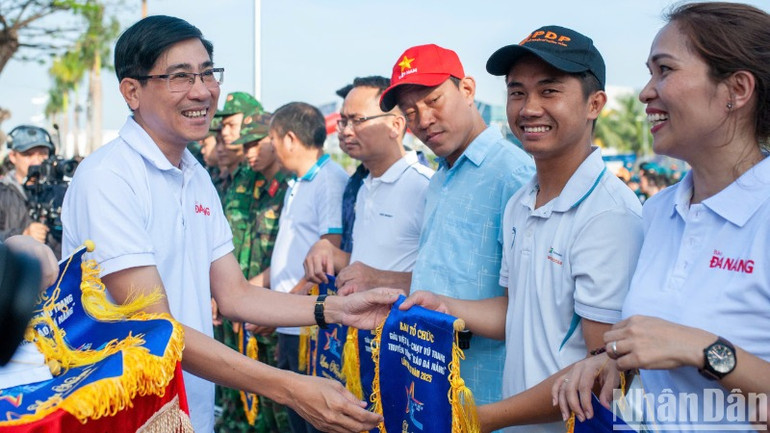 Trao cờ lưu niệm cho các đơn vị tham gia Giải Việt dã - chạy Vũ trang truyền thống Báo Đà Nẵng lần thứ 28.