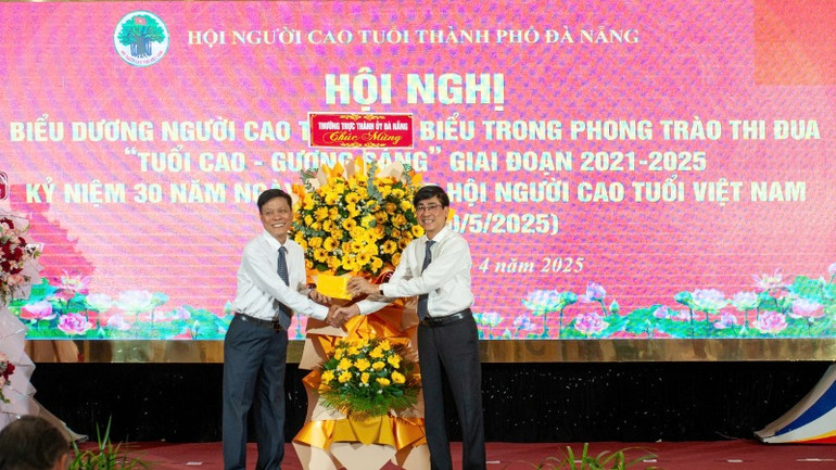 Đại diện lãnh đạo Thành ủy tặng hoa chúc mừng hội nghị.