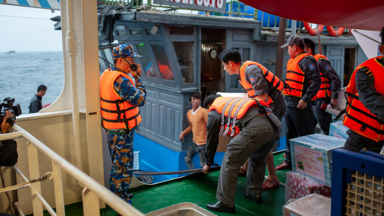 Các chiến sĩ kê ván gỗ chuyển quà.