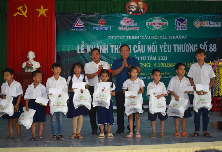 Trao quà cho học sinh nghèo vượt khó học giỏi ở xã Trung Chánh, huyện Vũng Liêm, tỉnh Vĩnh Long. (Ảnh: BÁ DŨNG)