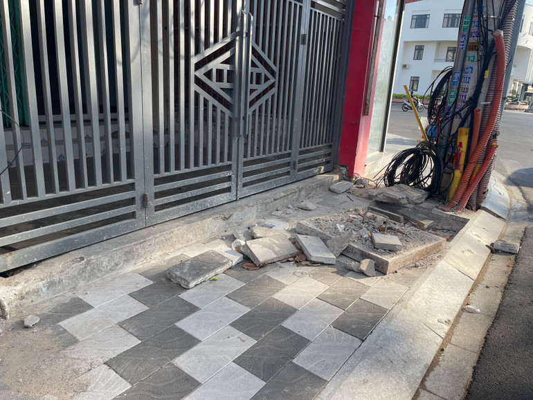 Nắp hố ga, những viên gạch vứt bừa bãi trước nhà dân.