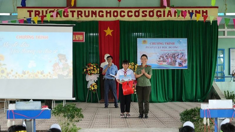 Đại úy Nguyễn Tú Trâm cán bộ đại diện Ban Phụ nữ Công an tỉnh trao quà và học bổng cho con đỡ đầu.