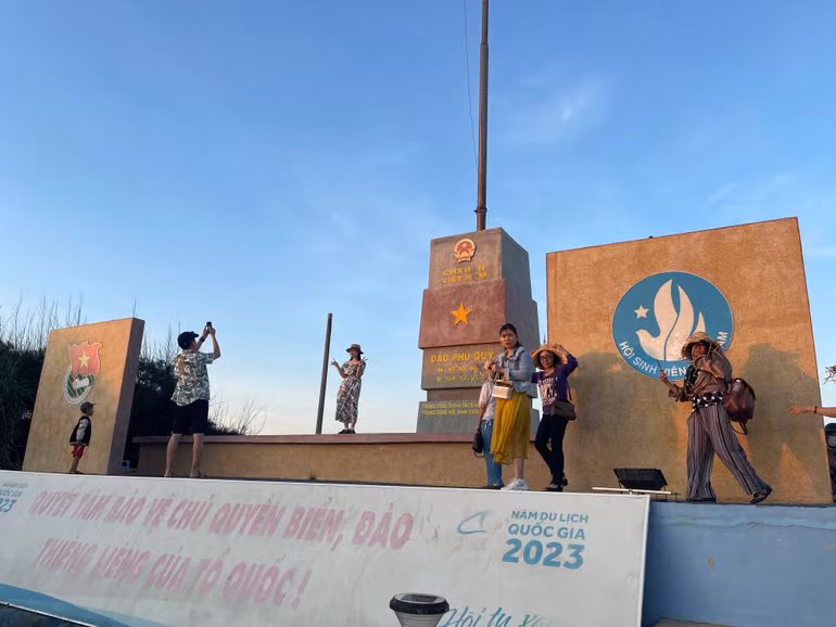 Du khách xếp hàng chụp hình cột cờ đảo Phú Quý.