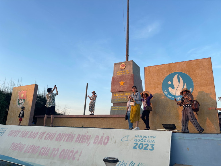 Du khách xếp hàng chụp hình cột cờ đảo Phú Quý.