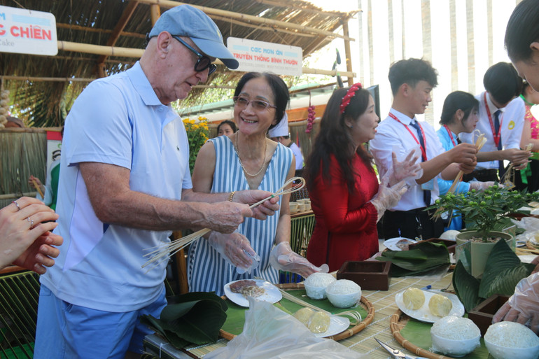 Thí sinh khách nước ngoài đang hào hứng với cách gói bánh chưng.