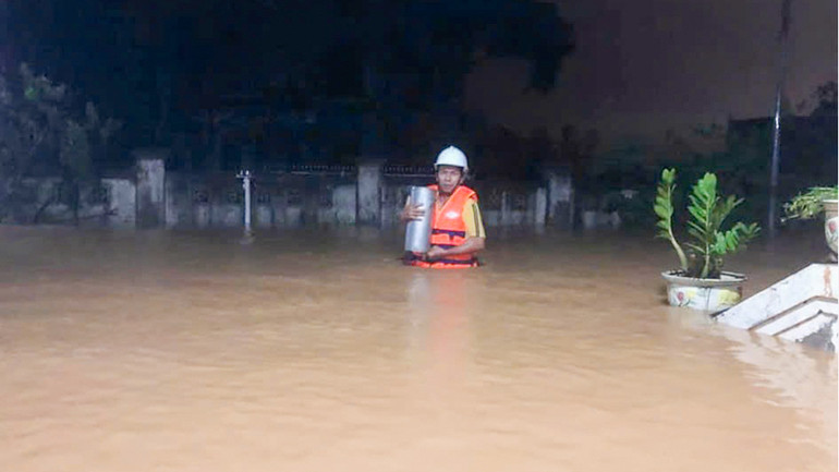 Cán bộ Đài Khí tượng Thủy văn Trung Trung Bộ đo mưa trong lũ.