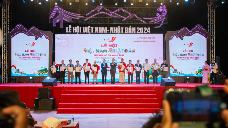 Lãnh đạo hai bên trao hoa cho các tổ chức, doanh nghiệp tham gia lễ hội.