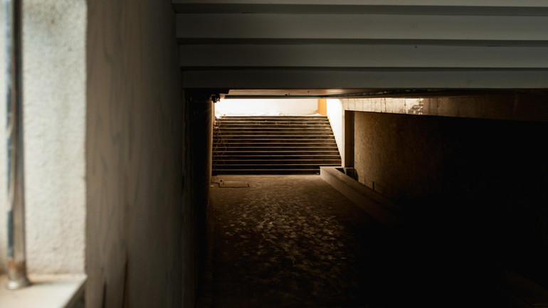 Không gian bên trong hầm đi bộ thiếu sáng, bụi bặm.