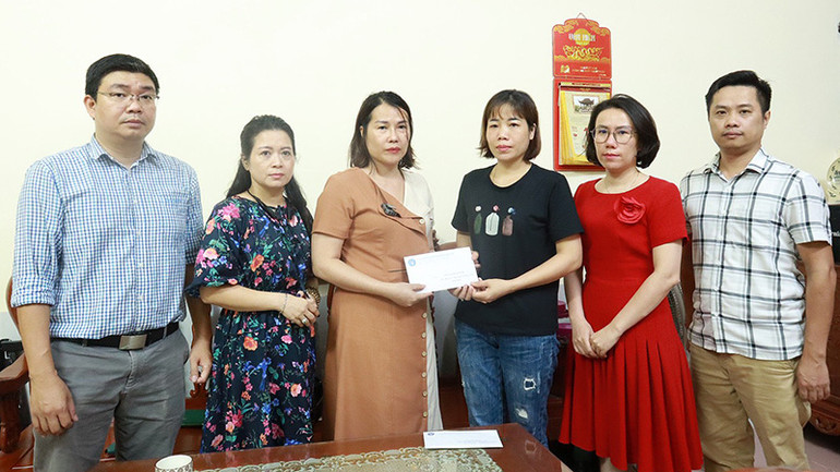 Bảo hiểm xã hội quận Thanh Xuân trao hỗ trợ cho gia đình các nạn nhân trong vụ cháy chung cư mini tại Khương Hạ. (Ảnh: Khánh Duy)