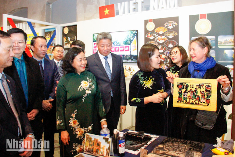 Bà Karine Yris, Giám đốc phụ trách phát triển thương mại và bảo trợ văn hóa - nghệ thuật của Trung tâm 104, được trải nghiệm làm tranh Đông Hồ. (Ảnh: MINH DUY)