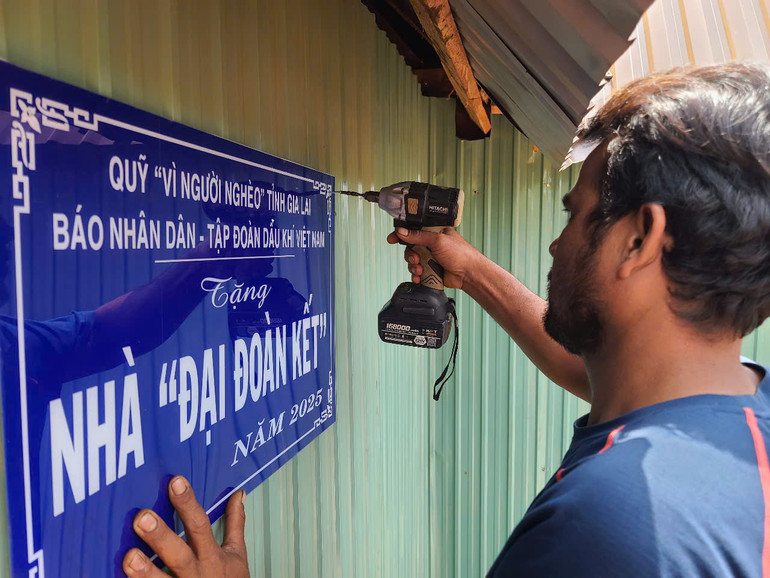 Bà con vui mừng gắn biển chuẩn bị cuộc sống mới trong ngôi nhà Đại đoàn kết.